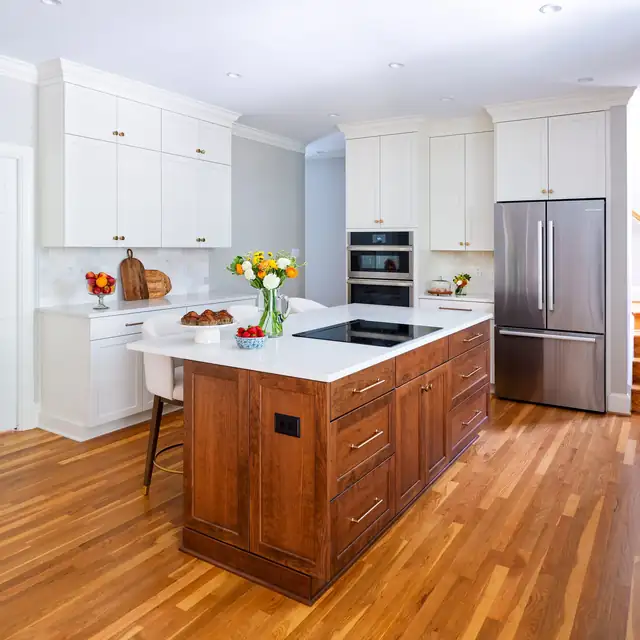 Kitchen near Wellesley with a cherry island, white perimeter cabinets, induction cooktop and oak floors