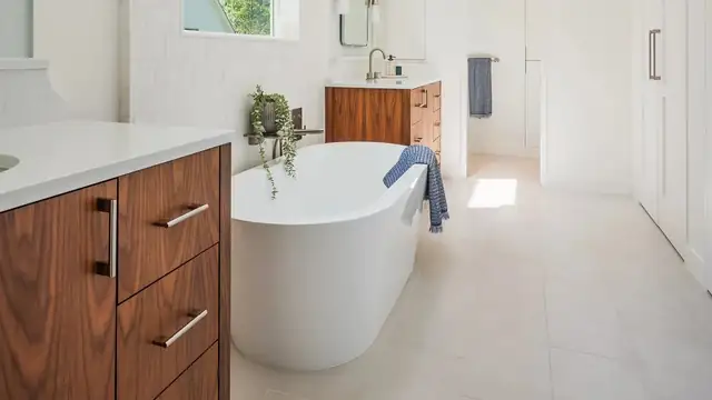 Richmond primary bathroom remodel with a walnut vanity, white quartz top and freestanding soaking tub