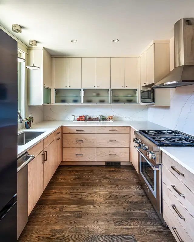 Galley kitchen with light wood cabinets, open shelving, a stainless range hood and dark wood floors