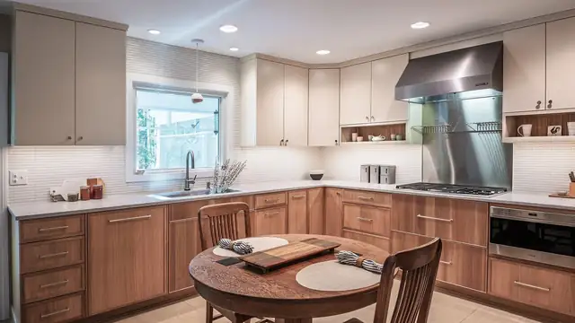 Scandi rustic Richmond kitchen with wood lower cabinets, taupe uppers, a stainless hood and round breakfast table